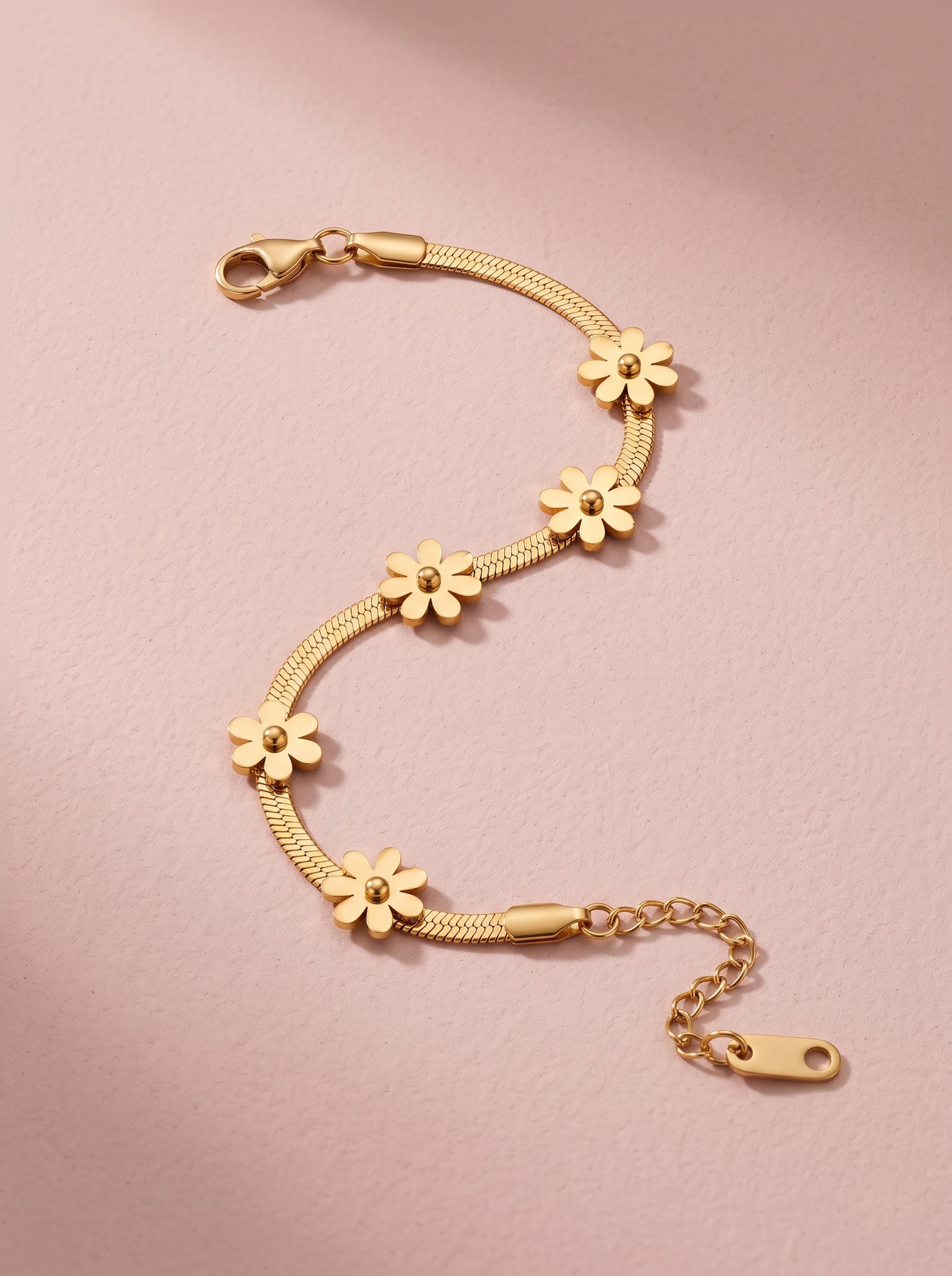 Gold daisy chain bracelet on pink fabric