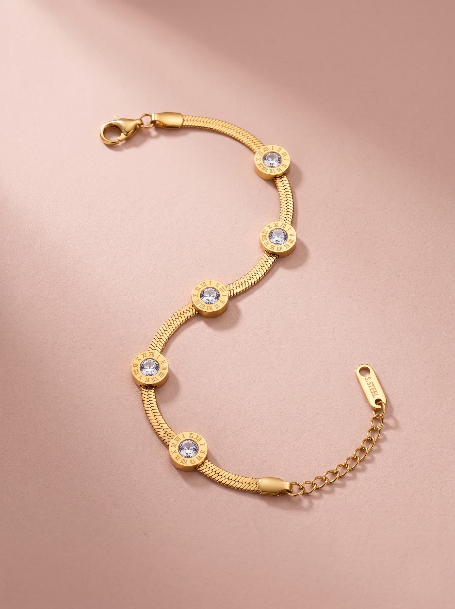 Gold Roman coin bracelet on pink fabric