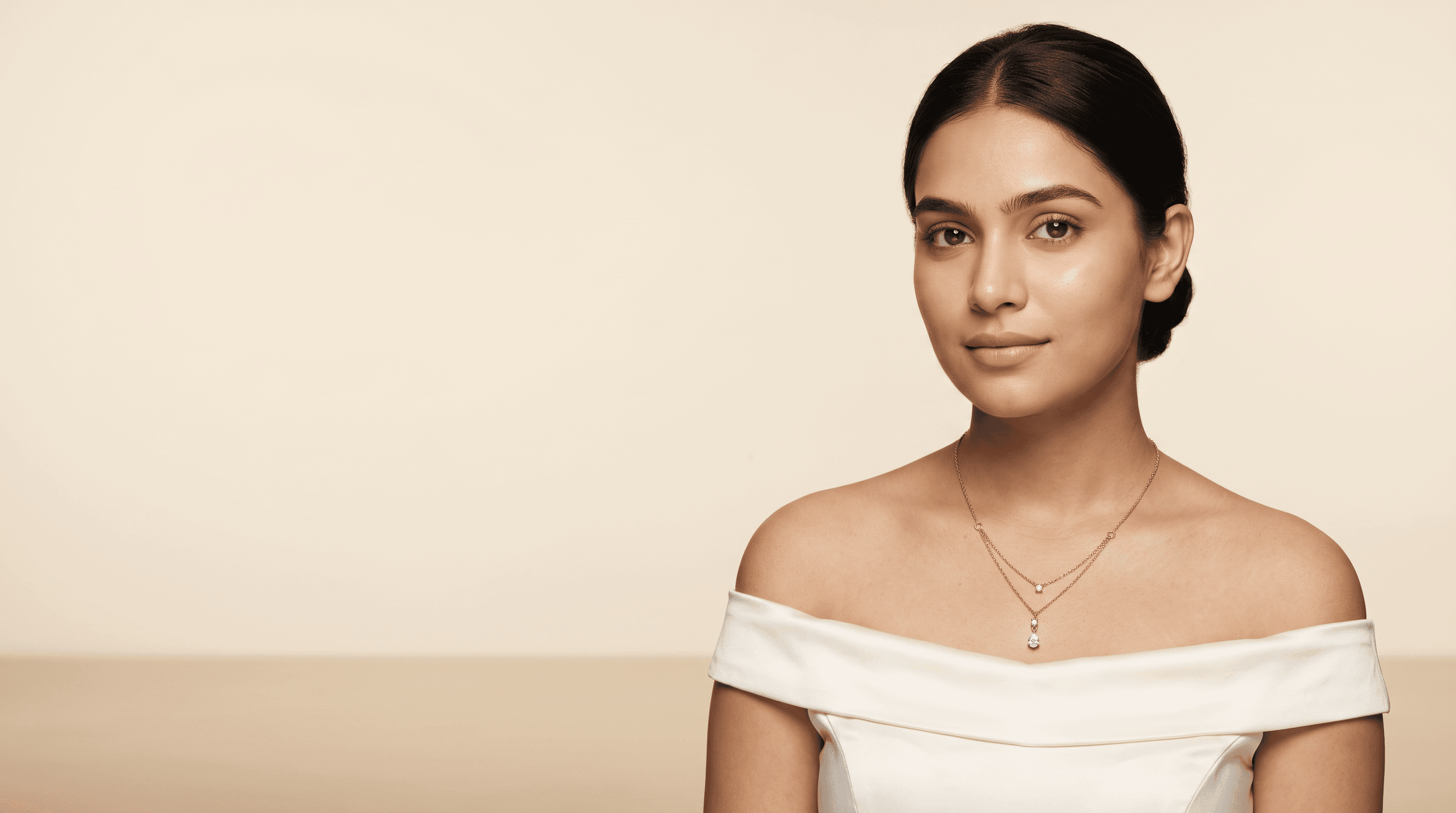 Model wearing a layered gold necklace from Svarniq Jewels