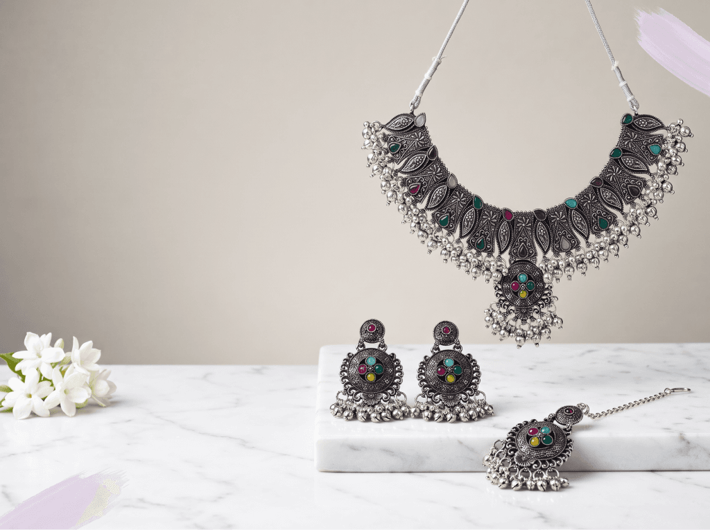Oxidised silver necklace, earrings and maang tikka on a marble slab