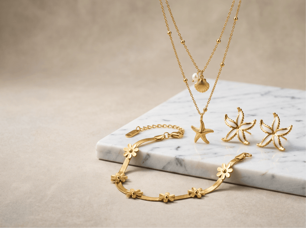 Gold starfish necklace, earrings and bracelet on a marble slab